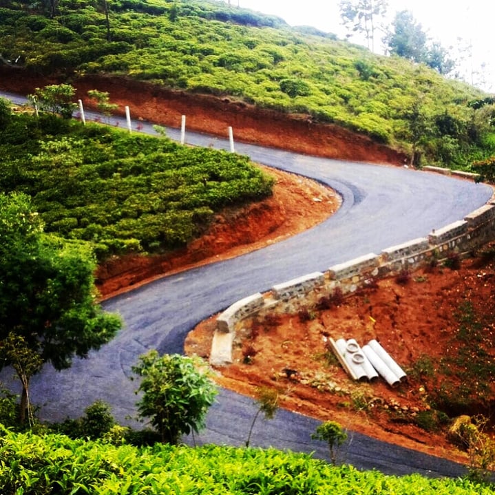 A winding road on the side of a hill located inside Amara, Ooty.